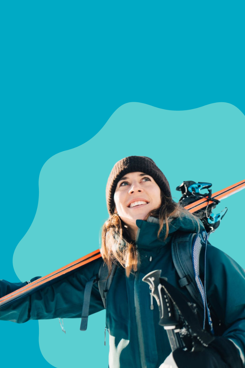 Person holding skis against a blue background
