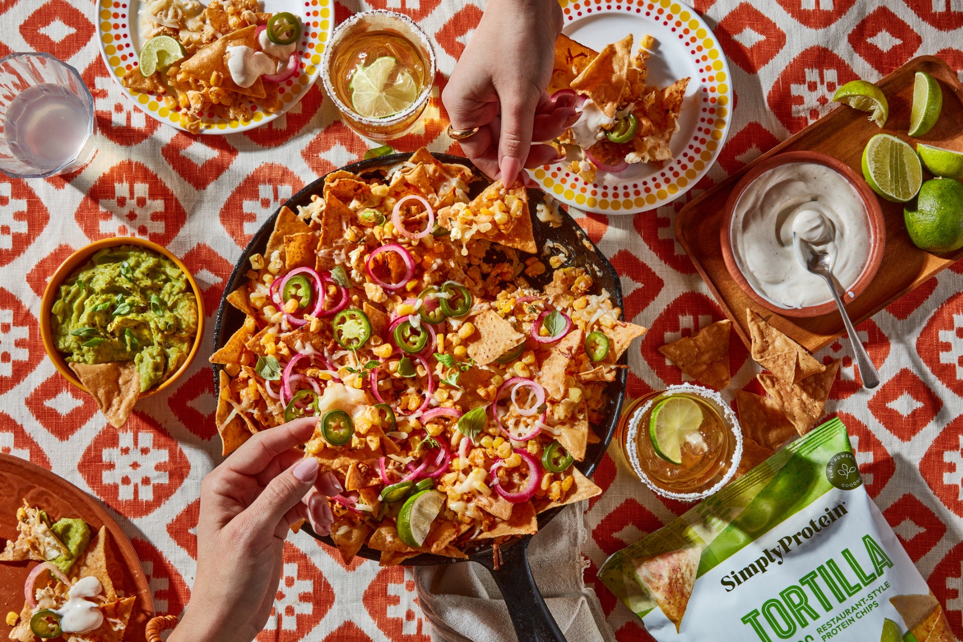 Photo of Mexican grilled corn nachos in a dish with hands sharing the food